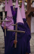 MEXICO, Oaxaca, Penitents wearing purple purple robes and hoods during Easter celebrations.
