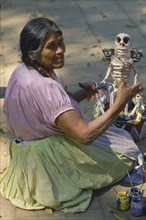 MEXICO, Festivals, Woman making skeleton figure for Day of the Dead.
