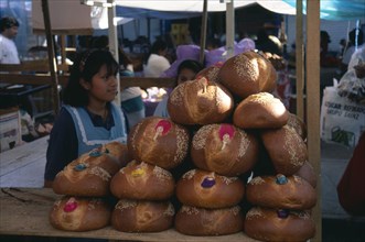 MEXICO, Oaxaca, Girls selling decorated bread for Day of the Dead.