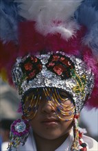 MEXICO, Mexico City, Portrait of dancer wearing feathered head dress celebratiing festival of Our