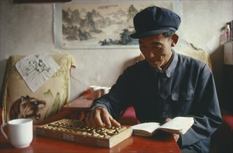 CHINA, Gansu, People, Farmer using an abacus to do his accounts.