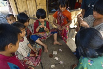 THAILAND, North, Chiang Rai, Lahu children playing cards.