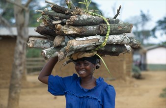 GHANA, People Carrying Goods, Young woman carrying bundle of firewood on her head.