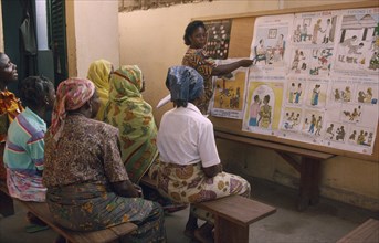 TOGO, Lome, Female teacher using story boards to demonstrate AIDS awareness and safe sex messages