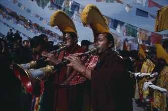 20061197 NEPAL  Bodhanath Monks of the Gelug pa sect proceed a photograph of the Dalai Lama playing shenai horns.
