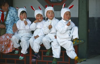 CHINA, Festivals, Children eating ice creams dressed up for Childrens Day  festivities.