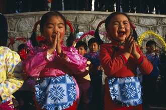 CHINA, Yunnan Province, Tribal People, Two small girls performing song.