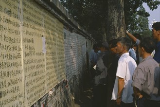 CHINA, Hebei, Beijing, Men reading posters on democracy wall.