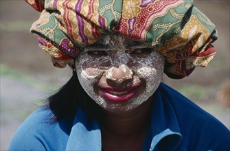 INDONESIA, Tribal People, Portrait of girl wearing rice flour on her face as sun protection.