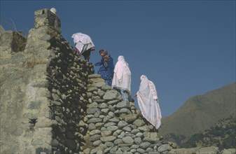 PAKISTAN, People, Women climbing stone footbridge.