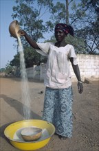 BURKINA FASO, Ouagadougou, Woman winnowing rice.