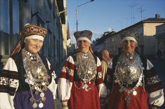 ESTONIA, Rakvere, Three female folk dancers in traditional costume.  Three quarter portrait.
