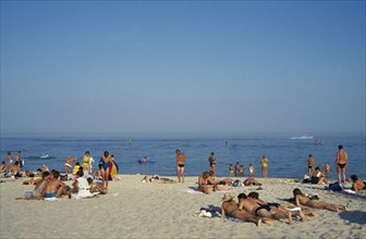UKRAINE, Odessa, People sunbathing on sandy beach beside the Black Sea.