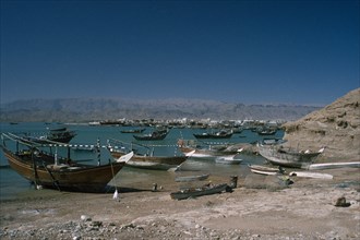 OMAN, Sur, Boats moored along coastline.