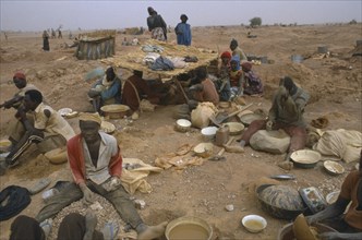 BURKINA FASO , Sahel, Gold miners working above ground in barren landscape.