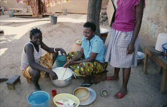 BURKINA FASO, Ouagadougou, Girls stirring milk.