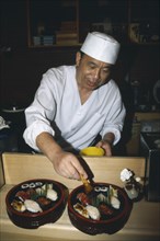 JAPAN, Honshu, Tokyo, Sushi chef preparing dish.