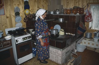 UKRAINE, Carpathian Mountains, Hutsul woman in kitchen.