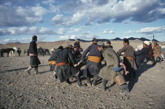 MONGOLIA, Southern Gobi, Men stretching felt for a yurt as part of a traditional wedding ceremony.