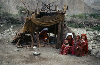 AFGHANISTAN, Tribal People, Kirghiz woman and children sitting outside tent while another woman