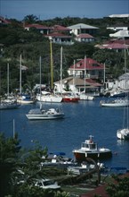 WEST INDIES, St Barthelemy, Gustavia, View over the port with white boats moored on water.