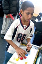 USA, Minnesota, St Paul, Young black child aged 10 playing video games developing his eye hand