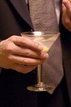 USA, Minnesota, St Paul, Business man holding martini cocktail at social gathering.