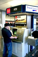 USA, Minnesota, Minneapolis, Father with baby son withdrawing cash at the ATM machine in the