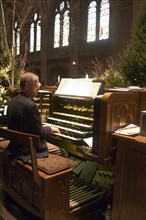 USA, Minnesota, Minneapolis, Basilica of St Mary organist playing music at the Christmas Pageant.