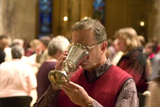 USA, Minnesota, Minneapolis, Catholic Parishioner sipping wine from chalice during communi at the
