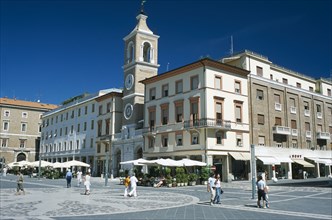 ITALY, Emilia-Romagna, Rimini, Town square with church and clock tower and cafes with outside
