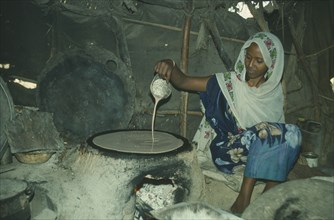 ETHIOPIA, Injerer, Woman cooking inside tent.