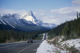 CANADA, Alberta, Banff National Park , Car on Trans-Canada highway through snow covered landscape.