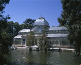 SPAIN, Madrid State, Madrid , Retiro Park. The Crystal Palace surrounded by trees seen from across