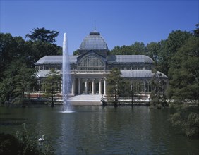 SPAIN, Madrid State, Madrid , Retiro Park. The Crystal Palace surrounded by trees seen from across