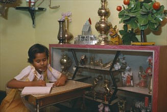 INDIA, Madhya Pradesh, Education, Ten year old girl doing homework in sitting room of middle class