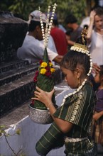 LAOS, Luang Prabang, Young girl in traditional dress with flower offering during New Year
