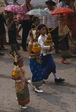 LAOS, Luang Prabang, Children in traditional dress carrying offerings at New Year celebrations.