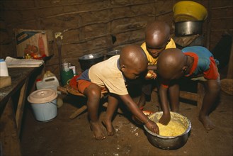 TANZANIA, West, Great Lakes Region, Refugee children eating maize porridge.