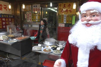 KOREA, Seoul , Namdaemun Market in December. Streetside restaurant with Santa Claus outside and a