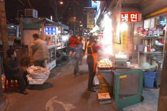 KOREA, Seoul, Namdaemun Market on a cold December night with street vendors and a young woman