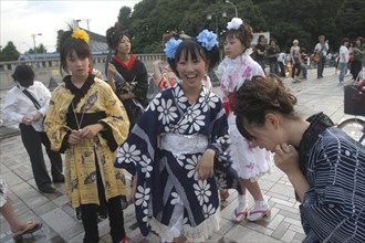 JAPAN, Honshu, Tokyo, Harajuku. Members of Kyoto Rokumeikan relax after dancing at the entrance of