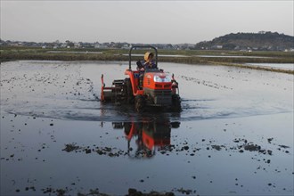 JAPAN, Chiba, Tako, "Mrs. Katsumata, over 70 years old, drives tractor preparing rice field in