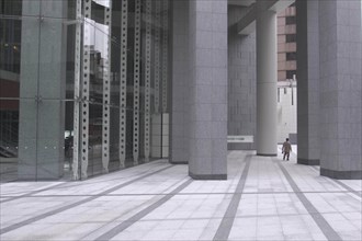 JAPAN, Honshu, Tokyo, "Roppongi ""Salariman"" officeworker crosses building plaza"