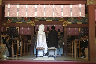 JAPAN, Honshu, Tokyo, "Nezu Jinja. Shinto priests give sake to bride and groom, both in traditional