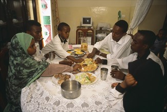 SOMALILAND, Hageisa, Middle class children eating lunch at home.  Food is taken from one central