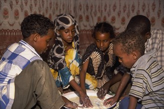 SOMALIA, Baidoa, Children eating meal at home from communal dish using the right hand.  At a family