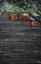 SRI LANKA, Mihintale, Monks climbing the steep pathway carrying umbrellas to shade themselves from