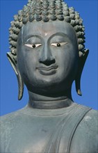 SRI LANKA, Colombo, Seema Malakaya on Beira Lake. Face of a Buddha statue against a blue sky