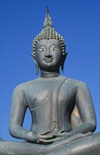 SRI LANKA, Colombo, Seema Malakaya on Beira Lake. Seated Buddha statue against a blue sky